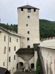 A historic stone tower at Schloss Bruck, an iconic castle in Lienz surrounded by lush greenery. Exploring this landmark is one of the 15 best things to do with kids in Lienz.