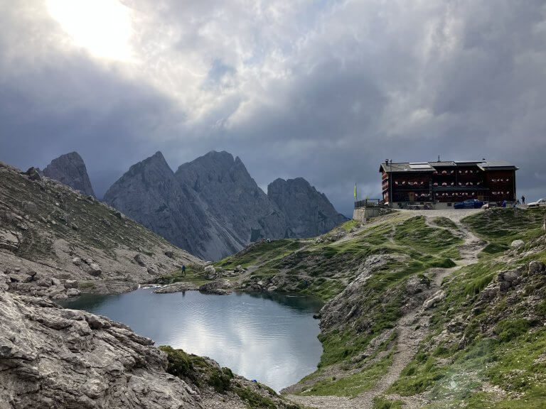 The Laserzsee lake with the Karlsbaderhütte perched on a hill, surrounded by rugged alpine peaks