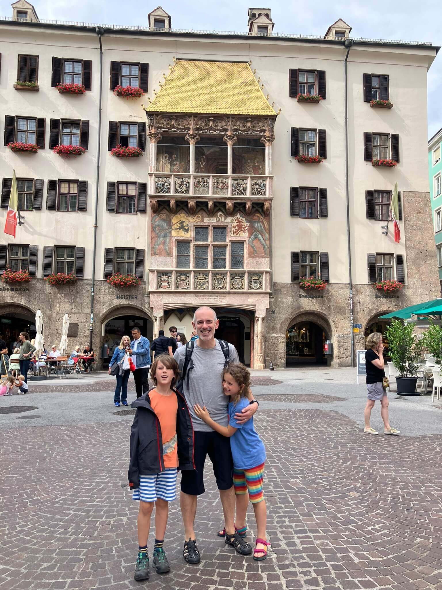 A family posing in front of the Golden Roof in Innsbruck’s old town, a historic landmark.