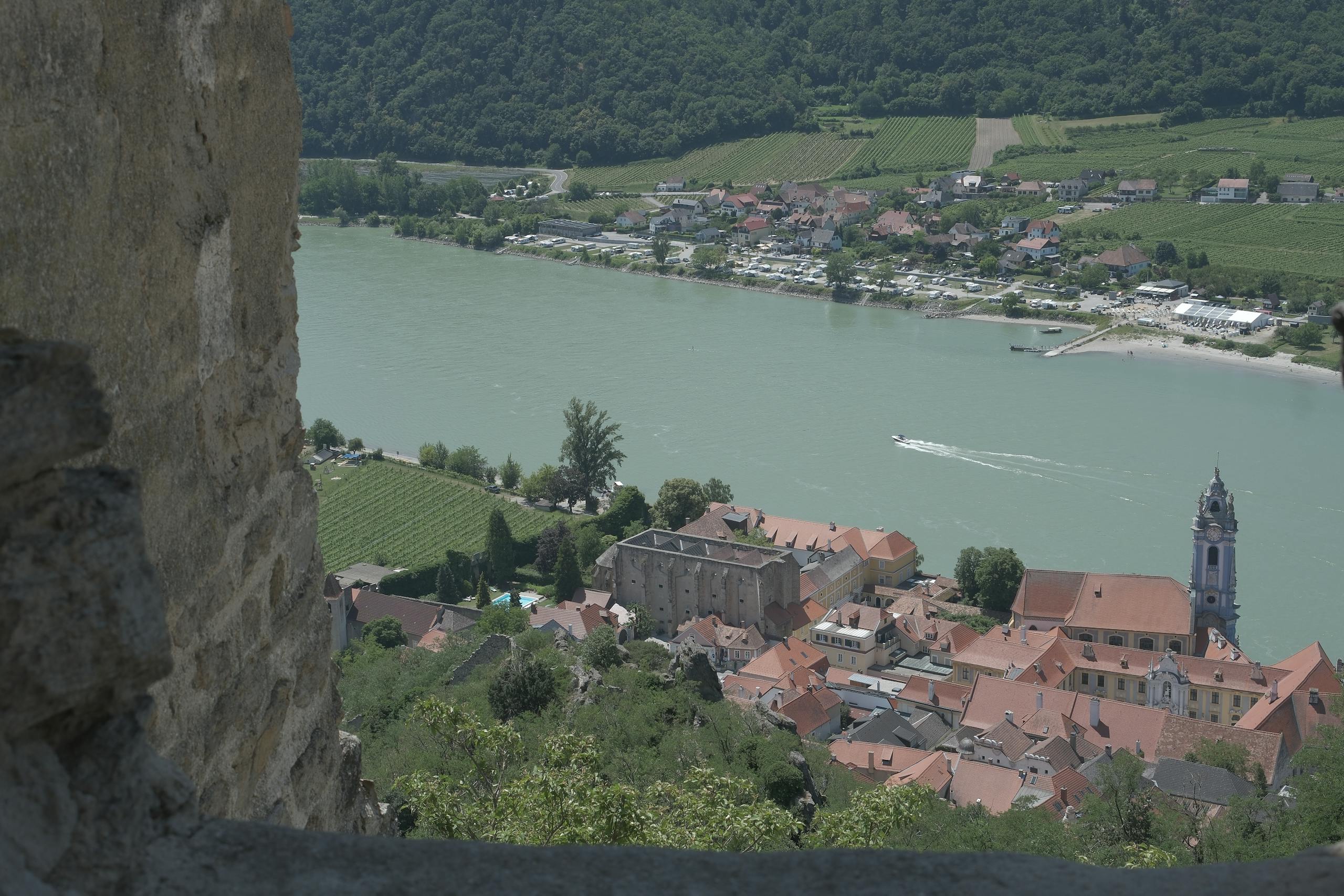 Explore the scenic view of Dürnstein and the Danube River framed by an ancient fortress wall.